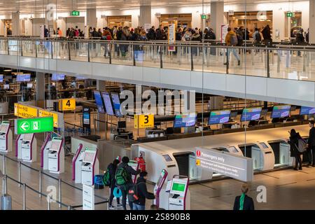 Passagiere gehen durch die Korridore des geschäftigen Flughafens Schiphol zu ihrem Ziel. Stockfoto