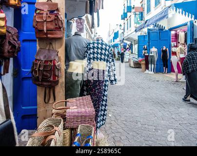 Der geschäftige Souk in Essaouira, Marokko, bietet farbenfrohe Stände und Einheimische, die in traditioneller Kleidung stöbern. Stockfoto