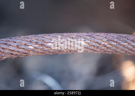 Eine rostige Kette wird in Nahaufnahme gezeigt. Die Kette ist alt und verschlissen und hat viele Löcher und Markierungen. Das Bild hat eine etwas düstere und melancholische Stimmung Stockfoto