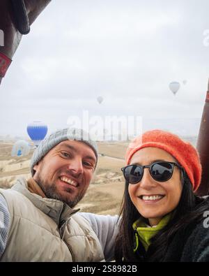 Goreme, Türkei - 27. dezember 2024: Schnelle Sicht über dem Heißluftballon Passagiere genießen im Winter die Aussicht im Heißluftballonkorb. Cappad Stockfoto