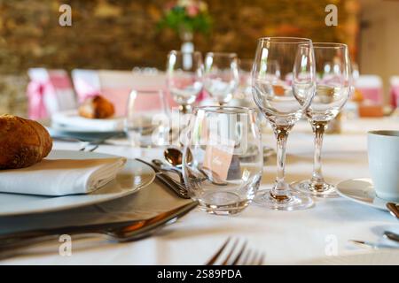 Elegante und elegante Tischdekoration mit Weingläsern, Brötchen und dekorativer Serviette Stockfoto