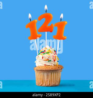 Orange Geburtstagskerze und Cupcake - Nummer 121. Stockfoto