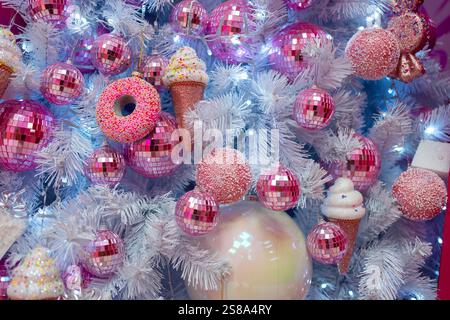 Großaufnahme verschiedener glänzender Kugeln und Dekorationen, die zu Hause am Weihnachtsbaum hängen. Vollformataufnahme festlicher Ausrüstung am Weihnachtsabend Stockfoto