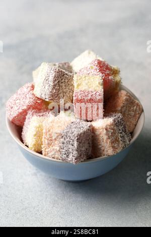 Farbenfrohe Kokosnuss-Leckereien in einer Schüssel, perfekt für festliche Zusammenkünfte und Feiern Stockfoto