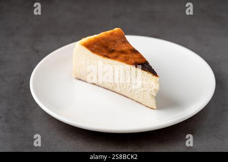 Beliebter spanischer Käsekuchen namens San Sebastian Käsekuchen auf einem Steintisch Stockfoto