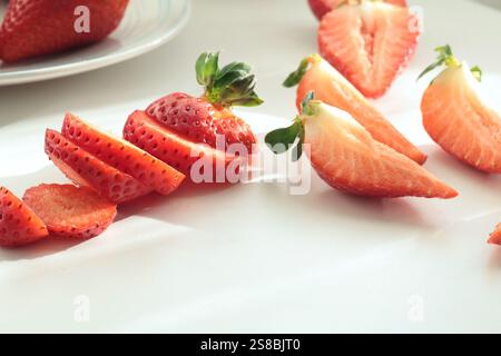 Gruppe geschnittener Erdbeeren aus dem Garten auf weißem Hintergrund. Umweltfreundliches reines Naturprodukt. Stockfoto