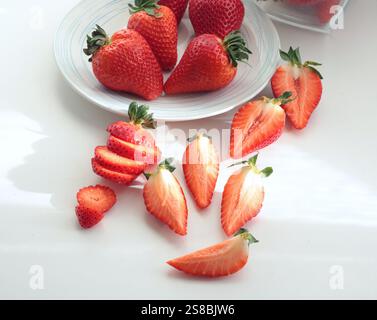 Gruppe geschnittener Erdbeeren aus dem Garten auf weißem Hintergrund. Umweltfreundliches reines Naturprodukt. Stockfoto