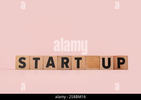 Würfel mit Wort-START auf rosafarbenem Hintergrund Stockfoto