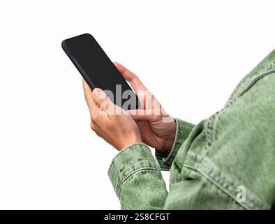 Isoliertes schwarzes Handy in den Händen einer Frau mit grüner Jacke. Stockfoto