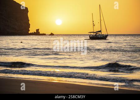 Sonnenaufgang während eines Sandsturms, Calima. Der schneebedeckte Horizont wird orange, wenn die Sonne wie ein Ball aufgeht. Ein Boot liegt im Meer vor Anker. Landschaftsfotogr Stockfoto