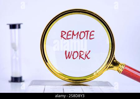 Eine Lupe, die die Worte Remote Work hervorhebt, lenkt die Aufmerksamkeit auf moderne Arbeitstrends in einer beruflichen Umgebung. Stockfoto
