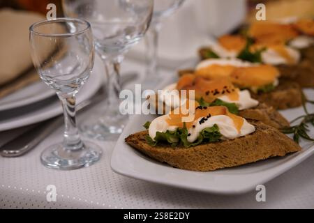 Appetitliche Sandwiches mit offenem Gesicht, geräucherten Lachs und Garnelen auf einem Tisch. Stockfoto