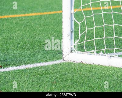 Nahaufnahme eines leeren Fußballtores auf einem hellgrünen Feld mit dem Gitternetz und sauberen weißen Linien. Perfekt für sportliche Projekte Stockfoto