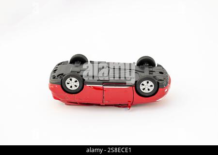 Wrackteile eines Toy Red Autos, das bei einem Verkehrsunfall kopfüber lag Stockfoto