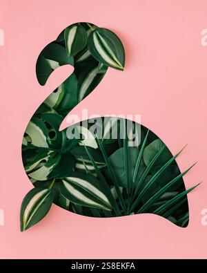 Sommerszene mit Flamingoform und tropischen grünen Blättern auf hellem pastellrosa Hintergrund. Minimales Sommer- und Frühlingskonzept. Stockfoto