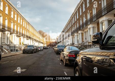 LONDON - Straße mit gehobenen Reihenhäusern im Zentrum von West London mit Parkplätzen auf der Straße Stockfoto