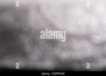 Ein verschwommener Hintergrund mit weichen Booker-Effekten mit einer Mischung aus hellen und dunklen Tönen, die eine abstrakte und traumhafte Atmosphäre schaffen. Stockfoto