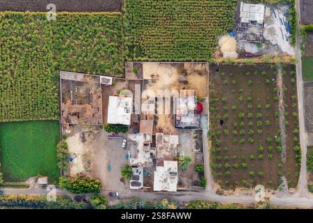 Aus der Vogelperspektive eine ländliche Landschaft mit Häusern im Bau neben bewirtschafteten Feldern. Stockfoto