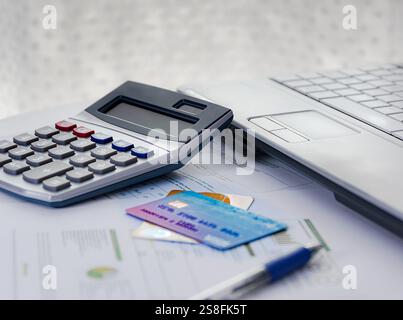 Kreditkarten auf einigen Dokumenten auf einem Tisch mit Rechner und Laptop. Stockfoto