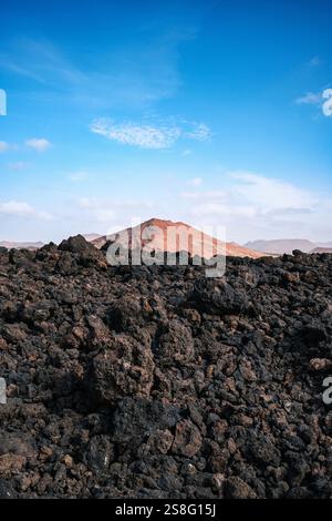 Atemberaubende vulkanische Landschaften mit schwarzem Sand, zerklüfteten Bergen und tiefblauem Himmel auf Lanzarote Stockfoto