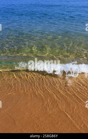 Portugal, Algarve. Wunderschöner türkisfarbener Atlantik mit kristallklarem Wasser, das auf einen einsamen Strand mit pudrigem Sand gespült wird. Stockfoto