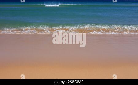 Portugal, Algarve. Wunderschöner türkisfarbener Atlantik mit kristallklarem Wasser, das auf einen einsamen Strand mit pudrigem Sand gespült wird. Stockfoto