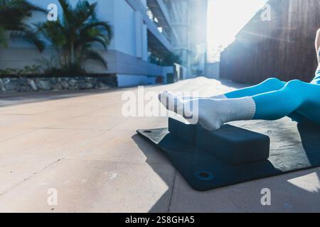 Nahaufnahme der Füße einer Frau während einer Yoga-Sitzung mit Yoga-Blöcken, Foto mit Kopierraum. Die Szene ist friedlich und entspannend, mit der Person Taki Stockfoto