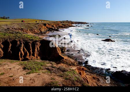 Die zerklüftete Küste in Cambria, Kalifornien, erstreckt sich entlang der Küste, wo Wellen sanft auf Felsen am Pacific Coastal Highway prallen Stockfoto