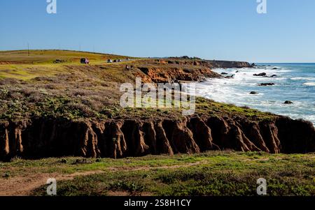 Die zerklüftete Küste in Cambria, Kalifornien, erstreckt sich entlang der Küste, wo Wellen sanft auf Felsen am Pacific Coastal Highway prallen Stockfoto