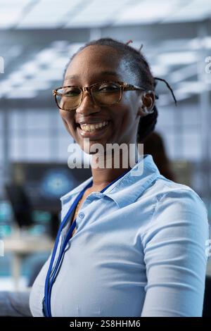 Porträt der glücklichen afroamerikanischen Computerwissenschaftler-Programmierung in KI-Rechenzentren, die für maschinelles Lernen verwendet werden. Jolly IT-Experte, der im Server-Hub-Büro an künstlicher Intelligenz arbeitet Stockfoto