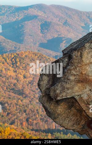 Die vertikale Aufnahme zeigt eine zerklüftete Felsformation, die von einem Berg ragt, mit hübschem Herbstlaub im Hintergrund, im Norden Georgiens Stockfoto