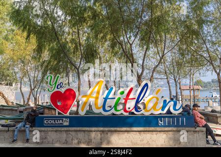 Santiago Atitlan, Solola, Guatemala. März 2024. Männer in einem Park neben einem Schild mit der Aufschrift „Ich liebe Atitlan“ in Guatemala. Stockfoto