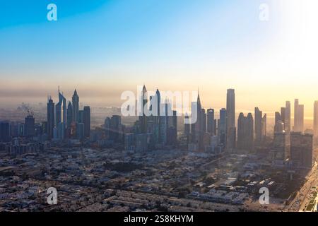 Panoramablick auf Dubai am frühen Morgen im Nebel. Sonnenaufgang in der futuristischen Skyline der Stadt mit Wolkenkratzern und Türmen von oben. Stockfoto
