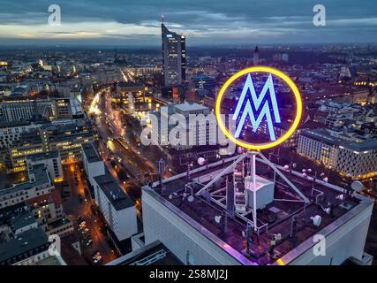 Leipzig, Deutschland. Januar 2025. Das Doppel-M der Leipziger Messe dreht sich morgens auf dem Wolkenkratzer Wintergarten, mit der Leipziger Innenstadt im Hintergrund. (Luftaufnahme mit Drohne) Credit: Jan Woitas/dpa/Alamy Live News Stockfoto