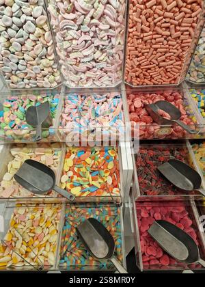 Farbenfrohe Auswahl an verschiedenen Bonbons, die in riesigen Glasbehältern präsentiert werden und eine Vielzahl von Formen und Aromen für ein süßes Erlebnis bieten Stockfoto