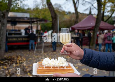 Weinfest in Schengen, Luxemburg, französischen oder luxemburgischen Waffeln mit Schlagsahne und einem Glas Jungwein, der im Herbst im Freien gegessen wird Stockfoto