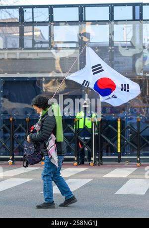 Seoul, Südkorea. Januar 2025. Ein Unterstützer des angeklagten südkoreanischen Präsidenten Yoon Suk Yeol geht an Polizeibeamten vorbei, die den Weg zum Seoul Verfassungsgericht mit einer Flagge blockieren. Der angeklagte südkoreanische Präsident Yoon Suk Yeol wird an seinem Amtsenthebungsverfahren teilnehmen. Quelle: SOPA Images Limited/Alamy Live News Stockfoto