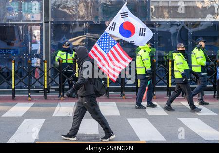 Seoul, Südkorea. Januar 2025. Ein Unterstützer des angeklagten südkoreanischen Präsidenten Yoon Suk Yeol geht an Polizeibeamten vorbei, die den Weg zum Seoul Verfassungsgericht mit einer Flagge blockieren. Der angeklagte südkoreanische Präsident Yoon Suk Yeol wird an seinem Amtsenthebungsverfahren teilnehmen. Quelle: SOPA Images Limited/Alamy Live News Stockfoto