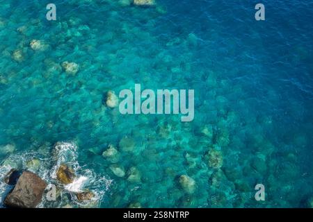 Blick auf die Felsen und das blaue, unberührte Meer mit klarem, transparentem Wasser. Ozeanhintergrund mit Kopierbereich Stockfoto