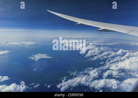 Über den Wolken über dem Indischen Ozean. Auf der linken Seite die Küste Indiens. Blick aus dem Flugzeugfenster während eines Fluges mit der Fluggesellschaft Etihad. Blau s Stockfoto
