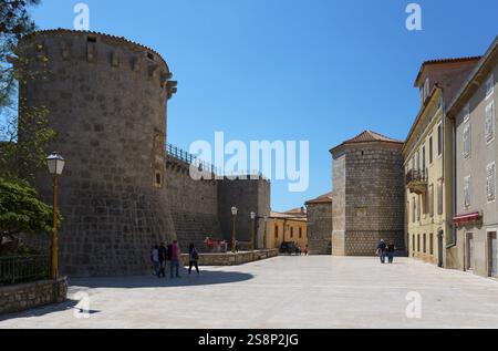 Urbane Szene mit mittelalterlichem Steinturm und Stadtmauer unter klarem blauen Himmel, Frankopan Castle, Kamplin Square, Altstadt, Krk Town, Insel Krk, Kvarner Stockfoto