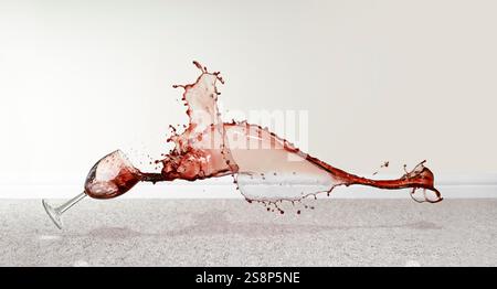 Ein heruntergefallenes Glas Wein, das über den Teppich geschüttet wurde Stockfoto