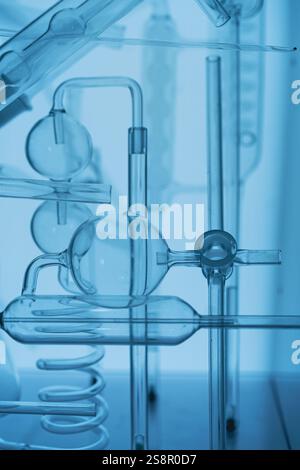 Wissenschaftliche Einrichtung mit Laborglas für chemische Experimente mit blauem Hintergrund Stockfoto