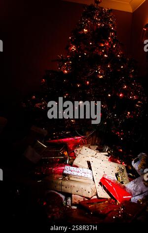 Wunderschön dekorierter Weihnachtsbaum mit Geschenken darunter im festlichen Raum Stockfoto