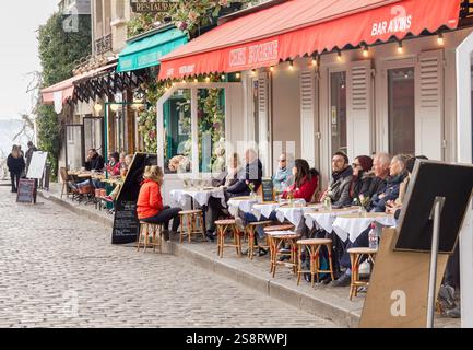 Paris, Frankreich - 6. März 2023: Menschen, die im Viertel Montmartre spazieren gehen. Das traditionelle Viertel ist berühmt für seine Künstler, Cafés, Restaurants und Stockfoto