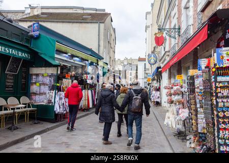 Paris, Frankreich - 6. März 2023: Menschen, die im Viertel Montmartre spazieren gehen. Das traditionelle Viertel ist berühmt für seine Künstler, Cafés, Restaurants und Stockfoto