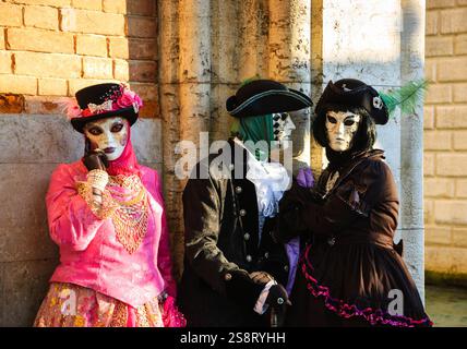 VENEDIG, ITALIEN - 16. FEBRUAR 2015: Drei Masken auf dem Markusplatz während des traditionellen Karnevals. Der Karneval in Venedig ist ein jährliches Ereignis, das Stockfoto