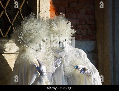 VENEDIG, ITALIEN - 16. FEBRUAR 2015: Zwei Pierrot-Masken auf dem Markusplatz während des traditionellen Karnevals. Der Karneval in Venedig ist ein jährliches Ereignis Stockfoto