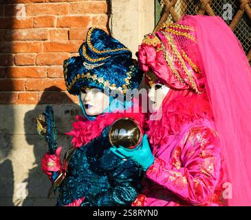 VENEDIG, ITALIEN - 16. FEBRUAR 2015: Zwei Masken (mit einer Kugel und einer Reflexion des Dogenpalastes) auf dem Markusplatz während des traditionellen Karnevals. Carniva Stockfoto