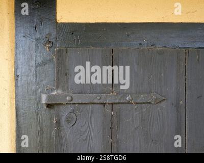 Türbeschläge für alte Schuppentüren im Fachwerk. Holztür in einer Fachwerkscheune. Die Türbeschläge mit der tiefen Holzmaserung. Stockfoto